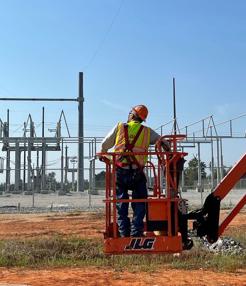 Power utility worker in aerial lift man basket