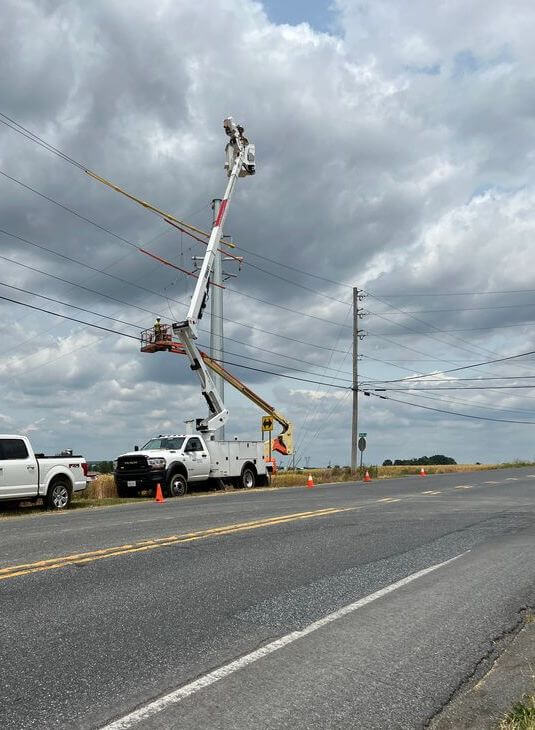Boom truck and skytrak with men in baskets working on transmission lines